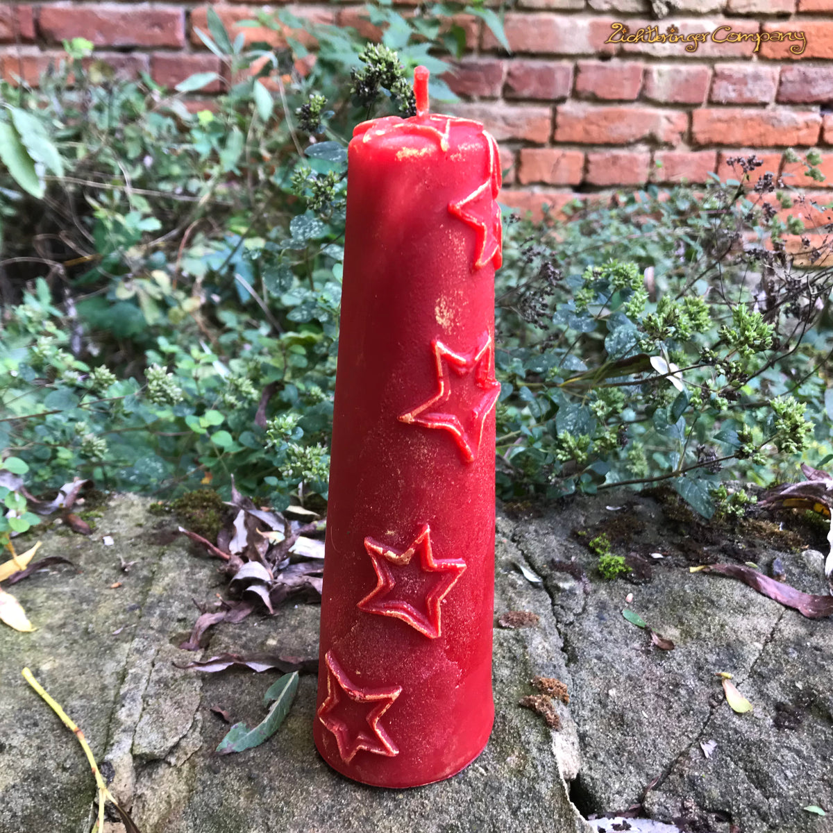 Kerze aus Bienenwachs mit Sternen und Glitzer. Farbe Bienenwach rot eingefärbt. Höhe 18 cm, Durchmesser 5,5 cm