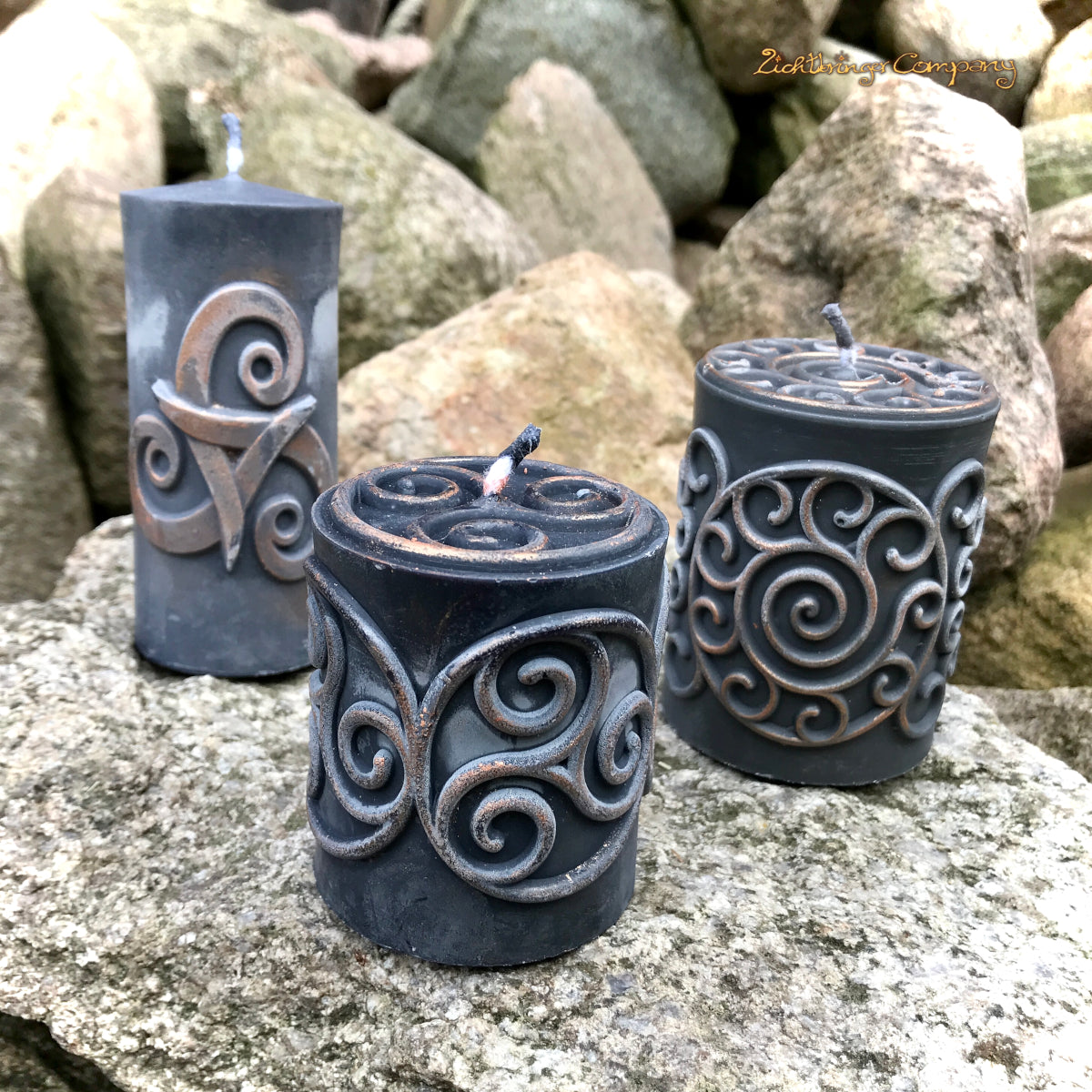 Schwarze Rapswachs-Stumpenkerzen mit Triskele- und Spirale-Motiv – Detailansicht mit Kupferglanz, handgefertigt von Lichtbringer Company