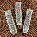 Drei kleine handgebundene Salbei-Lavendel Räucherbündel – Smudge Sticks zur energetischen Reinigung auf einem geflochtenen Weidenteller