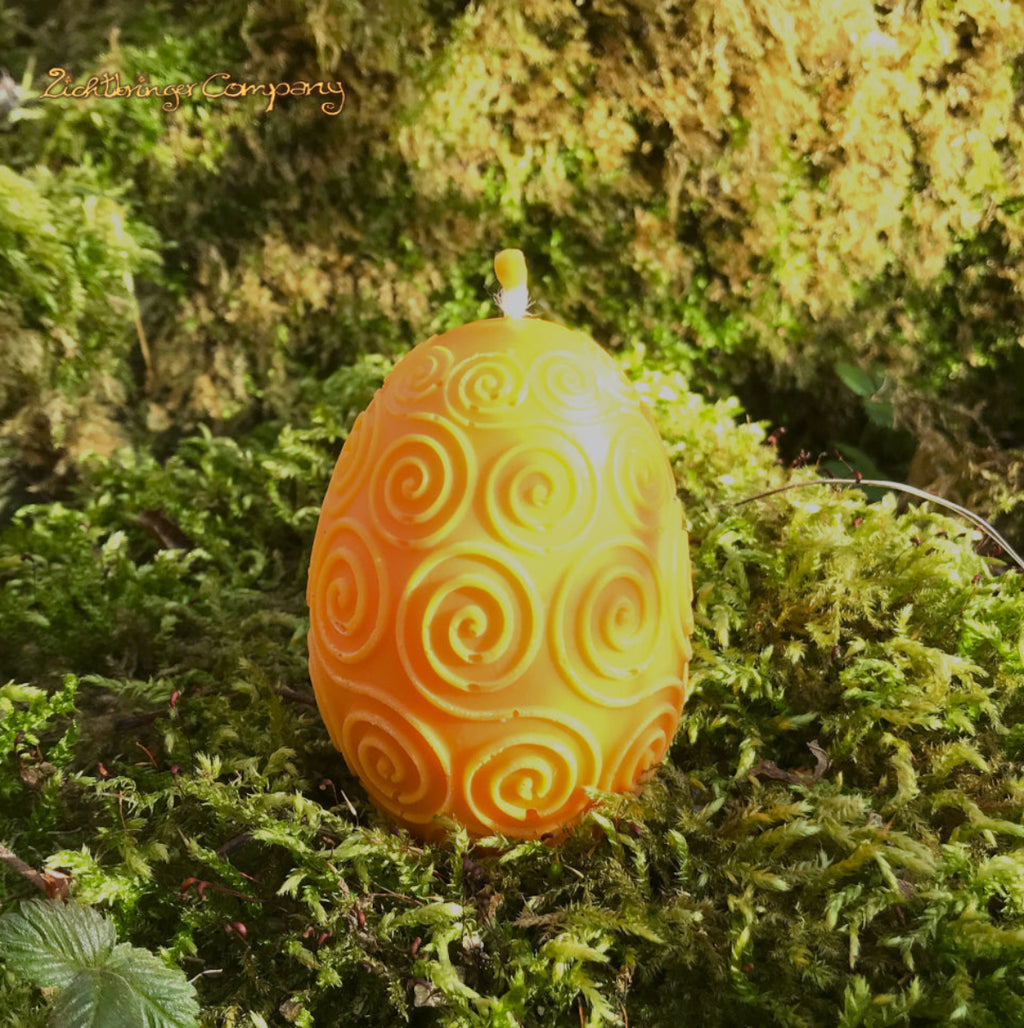 Rapswachs-Osterei mit Spiralen-Motiv in Gelb – handgegossene Kerze, Detailansicht auf Moosbett,  Höhe ca. 7 cm, von der Lichtbringer Company
