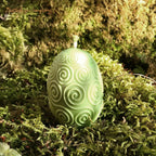 Rapswachs-Osterei mit Spiralen-Motiv in Grün – handgegossene Kerze, Detailansicht auf Moosbett, Höhe ca. 7 cm, von Lichtbringer Company