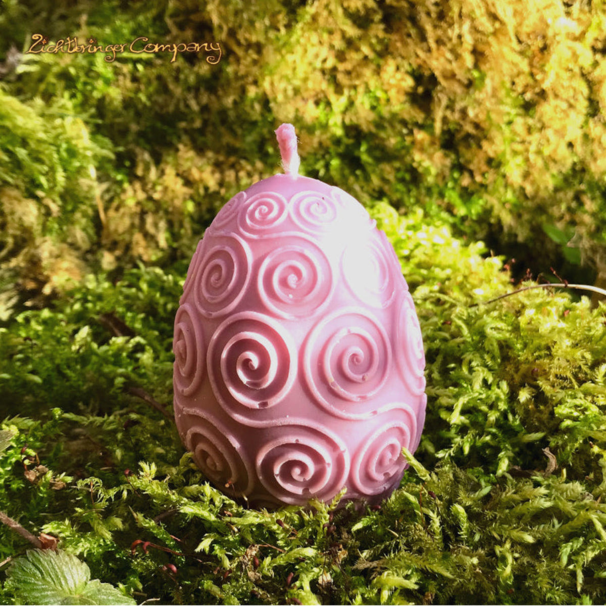Rapswachs-Osterei mit Spiralen-Motiv in Lila – handgegossene Kerze, Detailansicht auf Moosbett, Höhe ca. 7 cm, von Lichtbringer Company