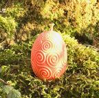 Rapswachs-Osterei mit Spiralen-Motiv in Orange – Detailansicht, handgegossene Kerze aus veganem Rapswachs von Lichtbringer Company