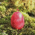 Rapswachs-Osterei mit Spiralen-Motiv in Rot – Detailansicht, handgegossene Kerze aus veganem Rapswachs von Lichtbringer Company
