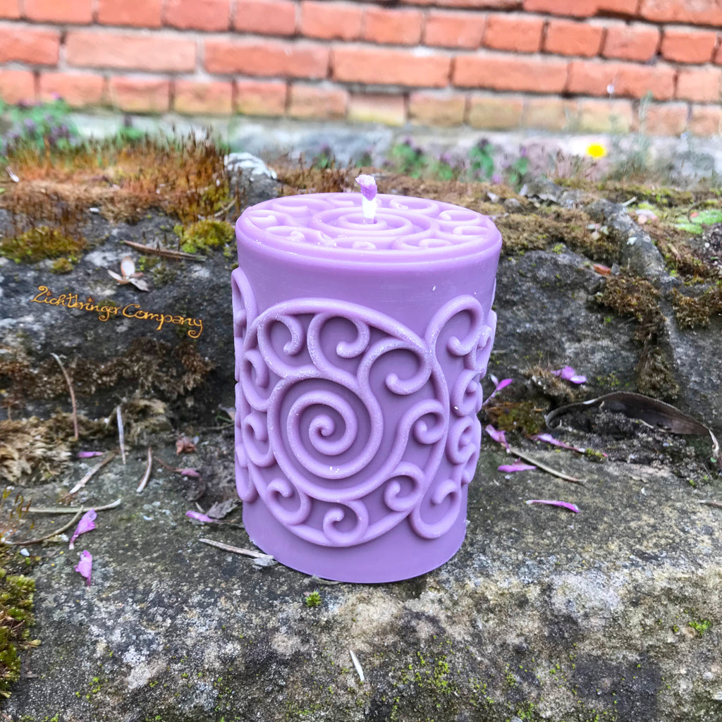 Spiralen-Stumpenkerze aus Rapswachs in Lila – keltisches Spiralsymbol, handgefertigt
